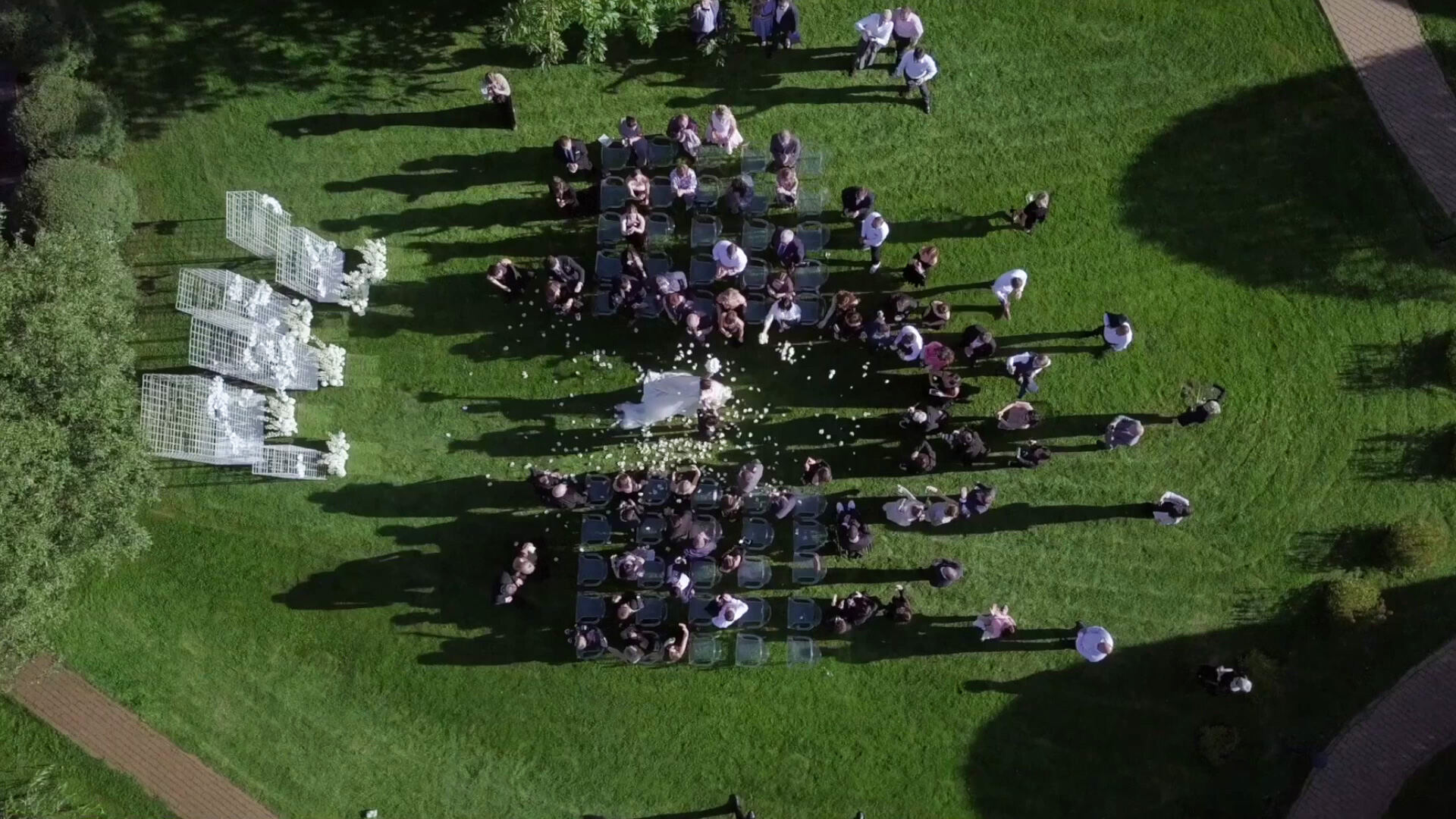 Aerial view of guests gathered on a lawn for an outdoor wedding ceremony