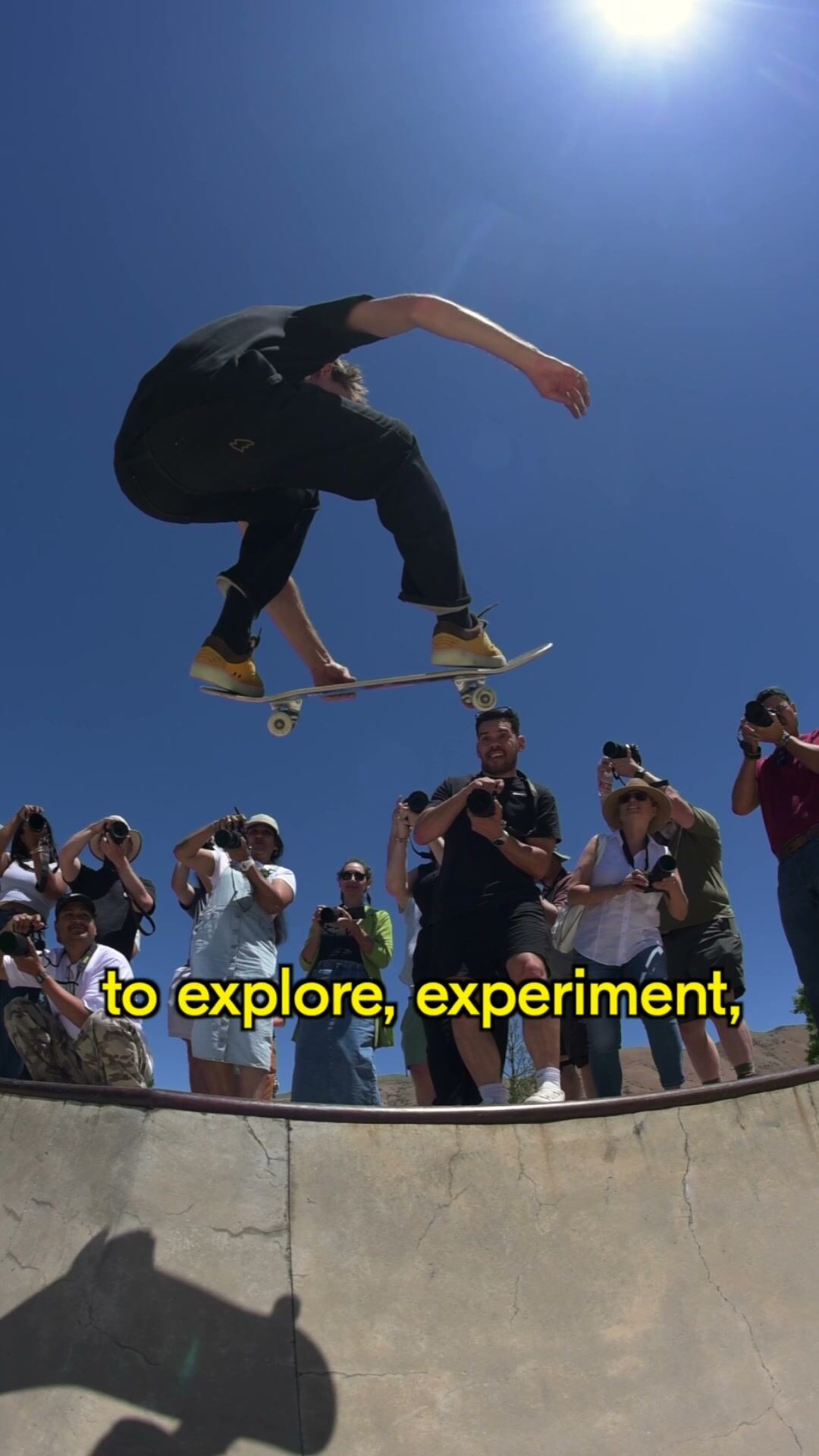 Skateboarder in mid-air above a crowd of photographers at a Salt Lake City skatepark